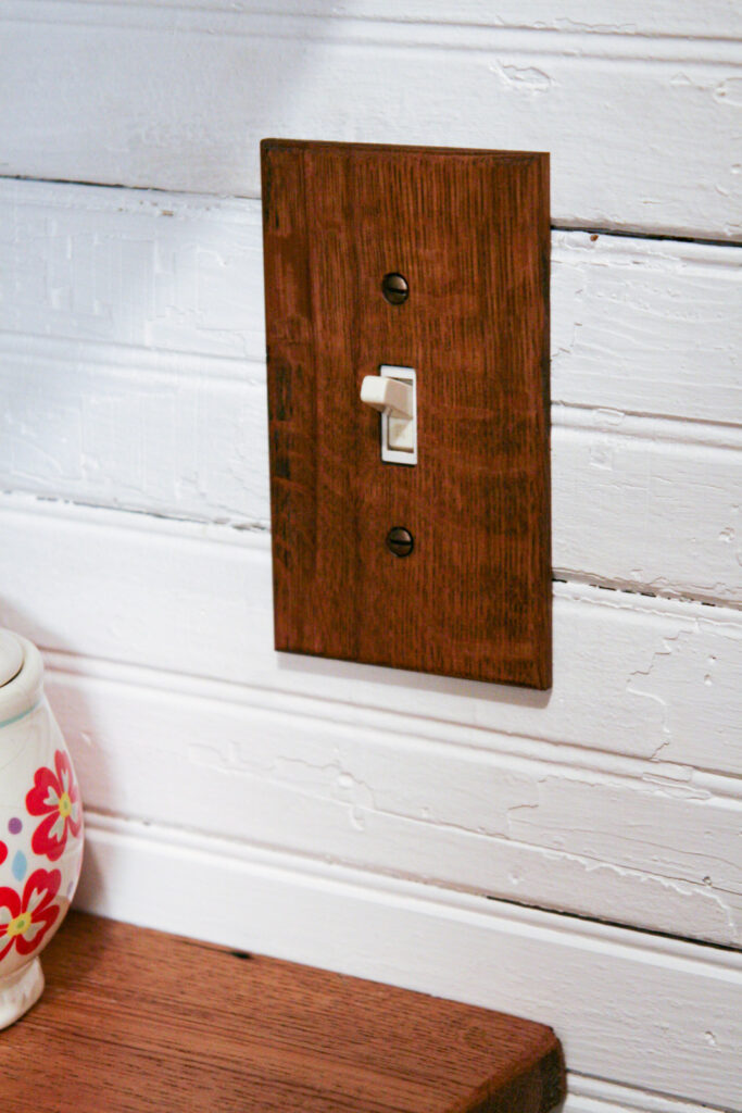 reclaimed oak wood light switch cover compliments shelving in a closet